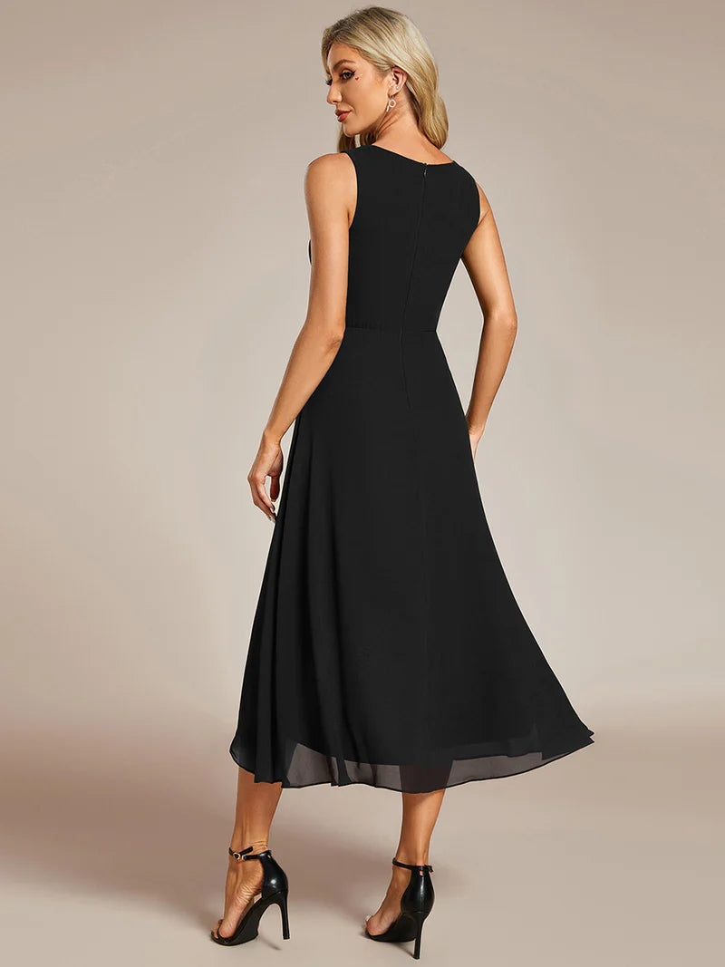 Black cocktail formal dress in chiffon with applique detail and sleeveless.