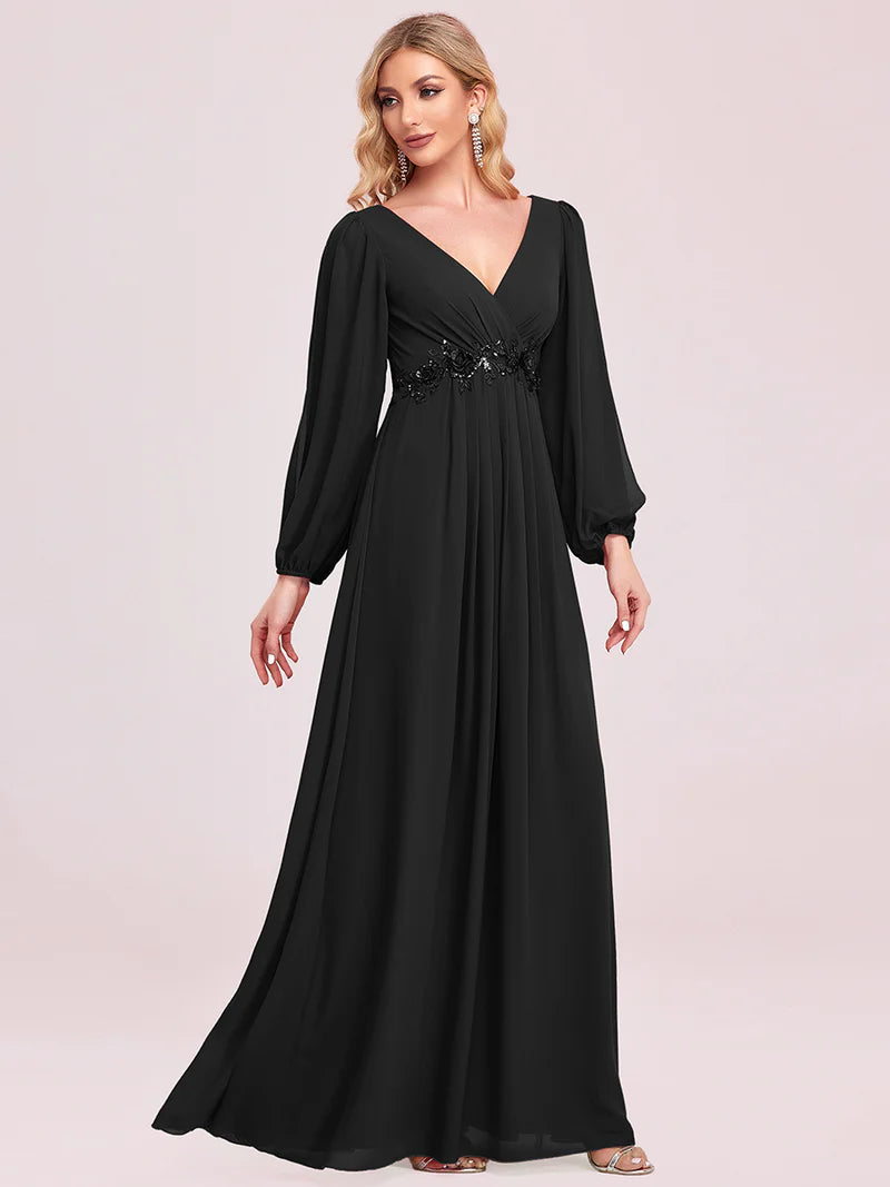 Black long sleeve formal dress with applique detail.