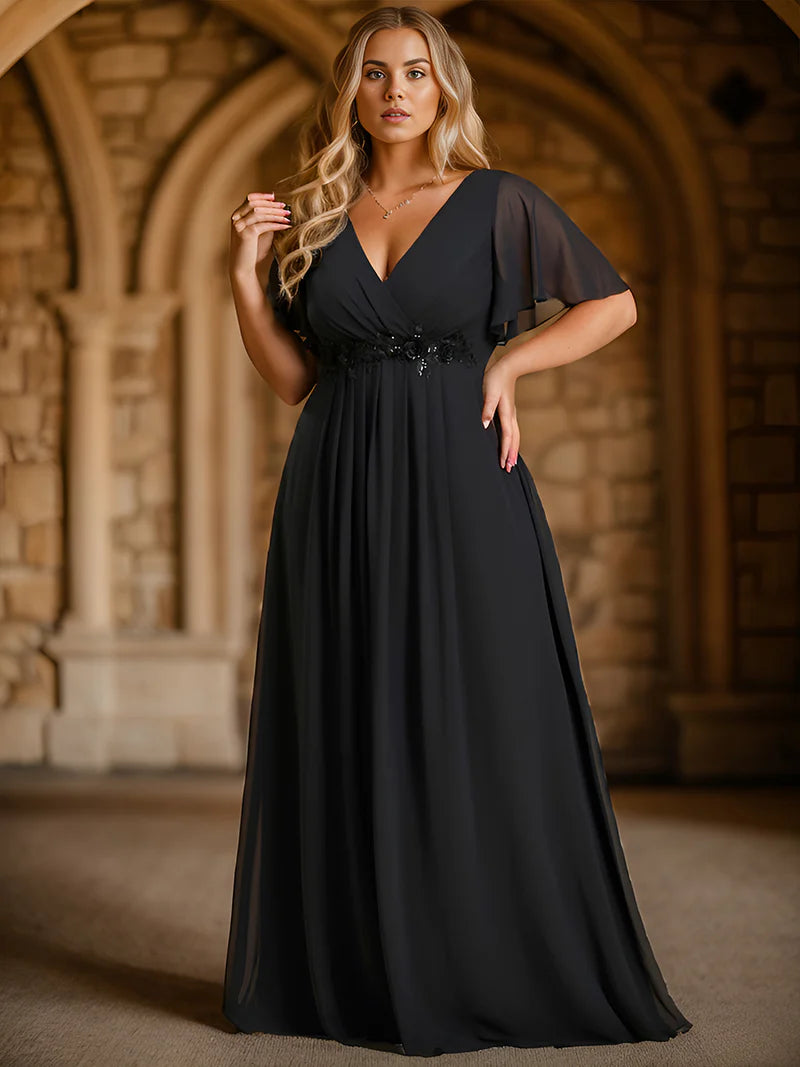 Black plus size formal dress with applique detail and short sleeve.