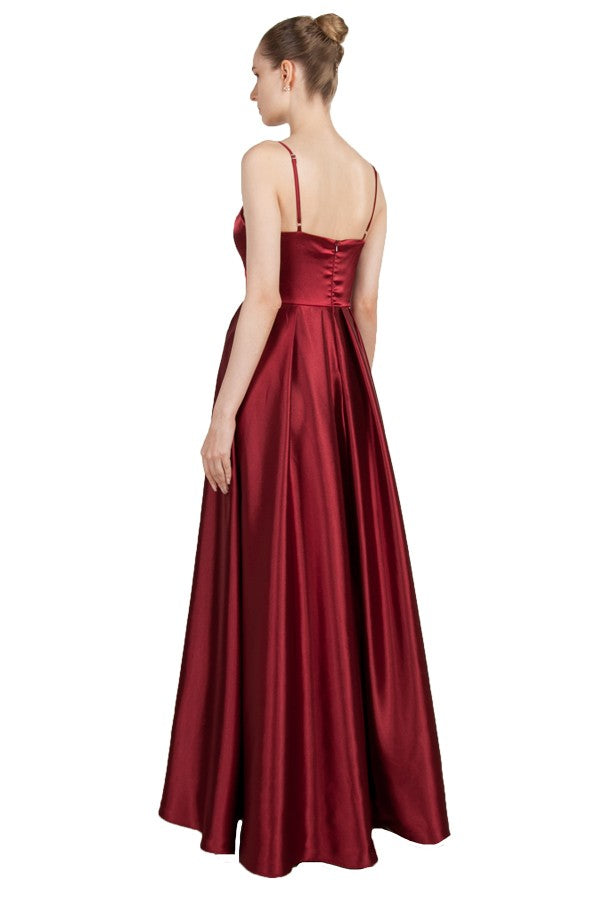 Burgundy satin formal dress with spaghetti straps and pockets.