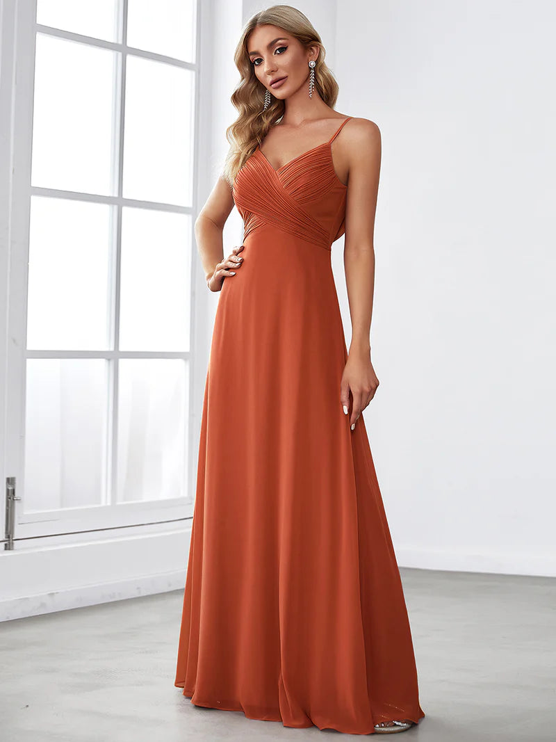 Sleeveless burnt orange bridesmaid dress with spaghetti straps.