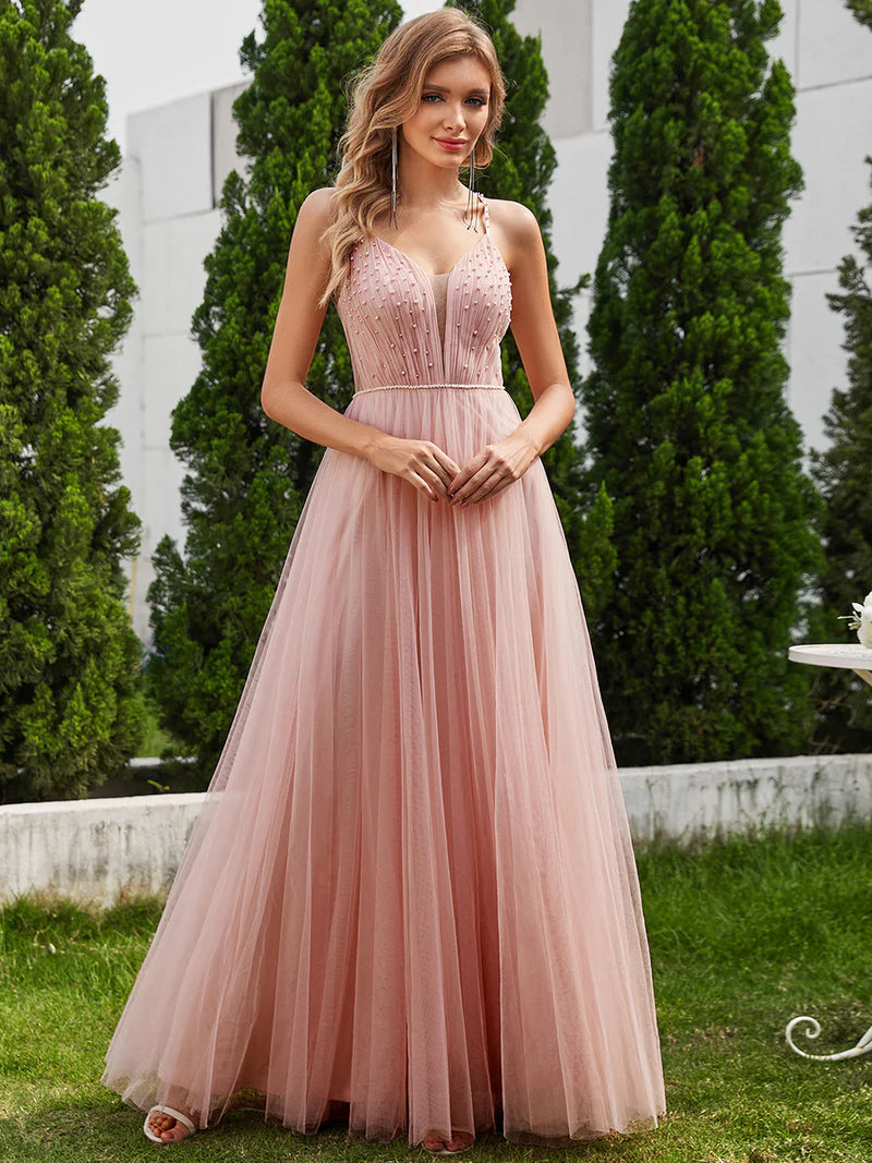 Dusty pink formal tulle dress with beaded pearl top and spaghetti straps.