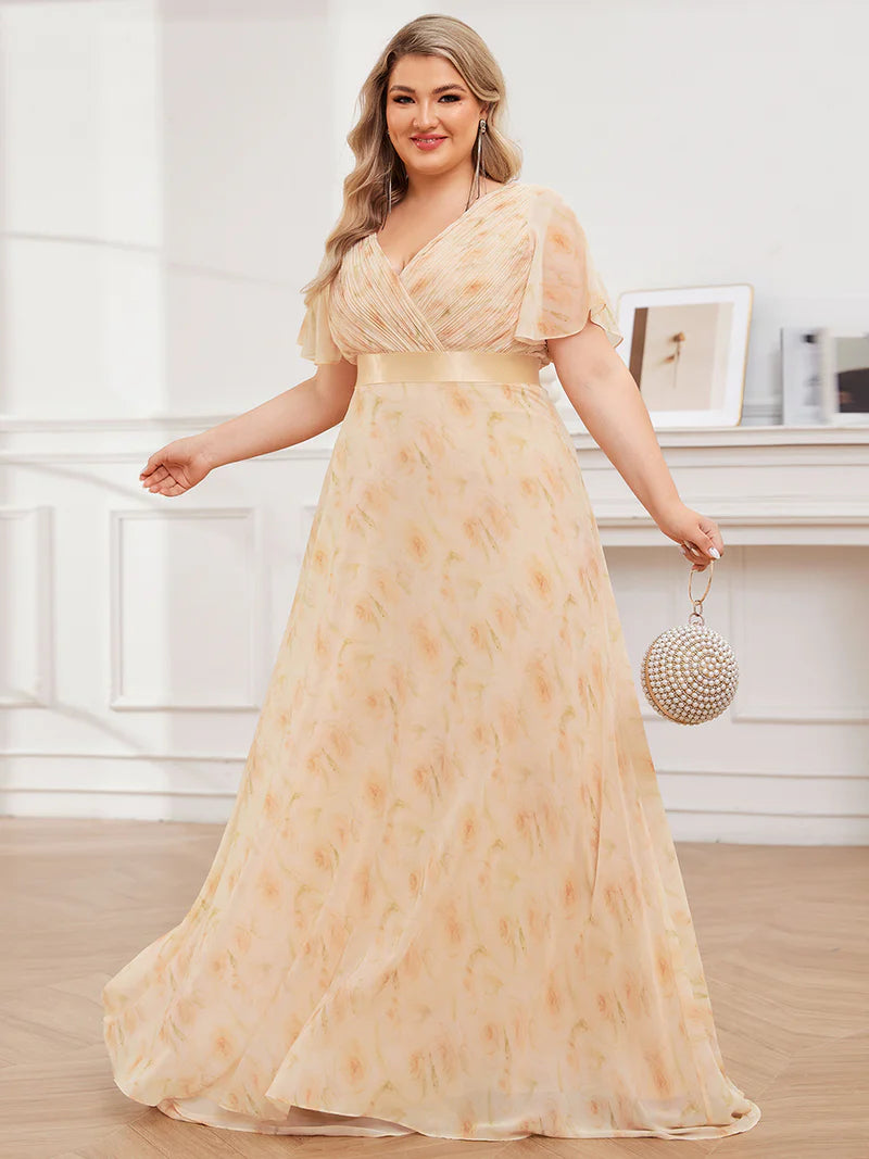 Floral peach plus size mother of the bride dress in chiffon with short sleeves and a satin band.
