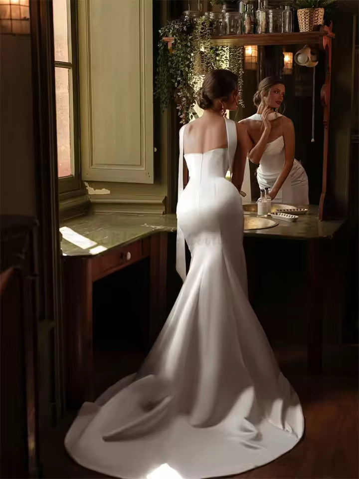 Ivory satin strapless wedding dress with mermaid tail and lace up back.