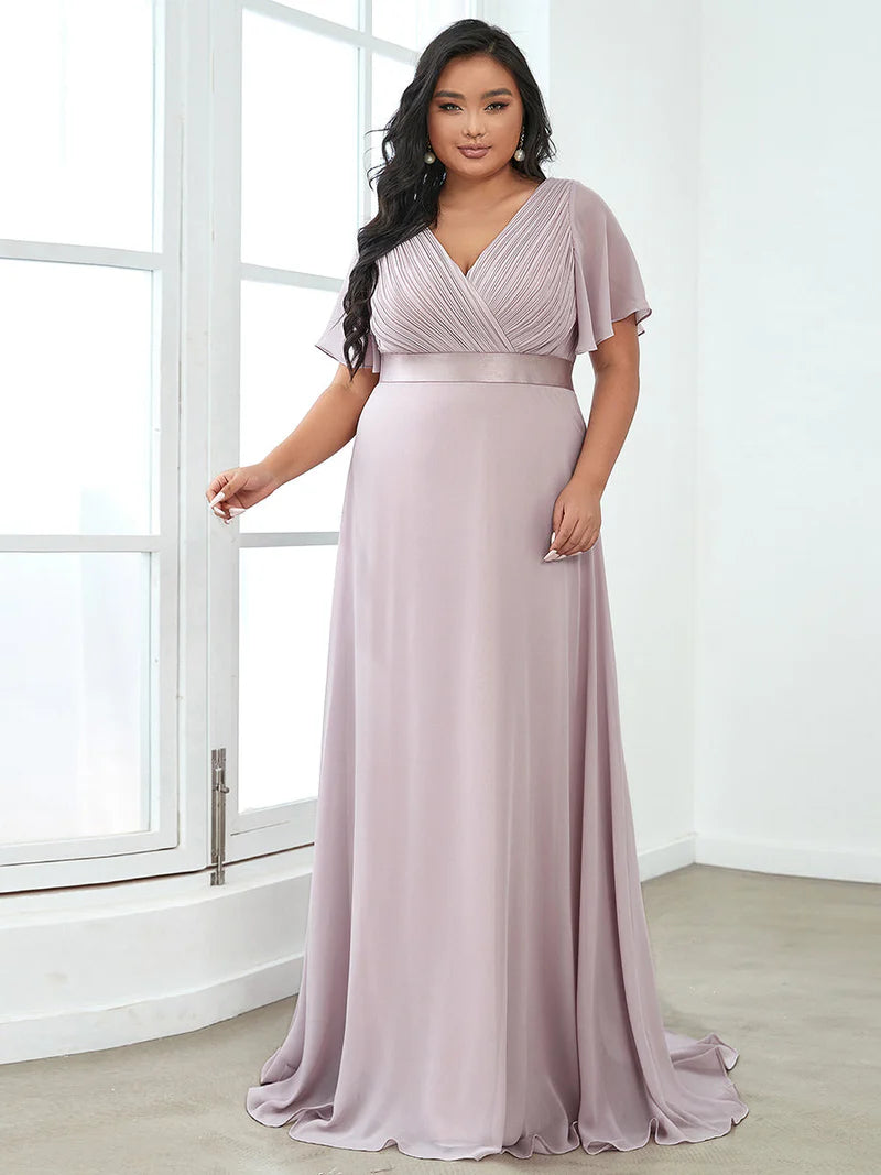 Lilac plus size bridesmaid dress or formal dress in chiffon with short sleeves and a satin band.