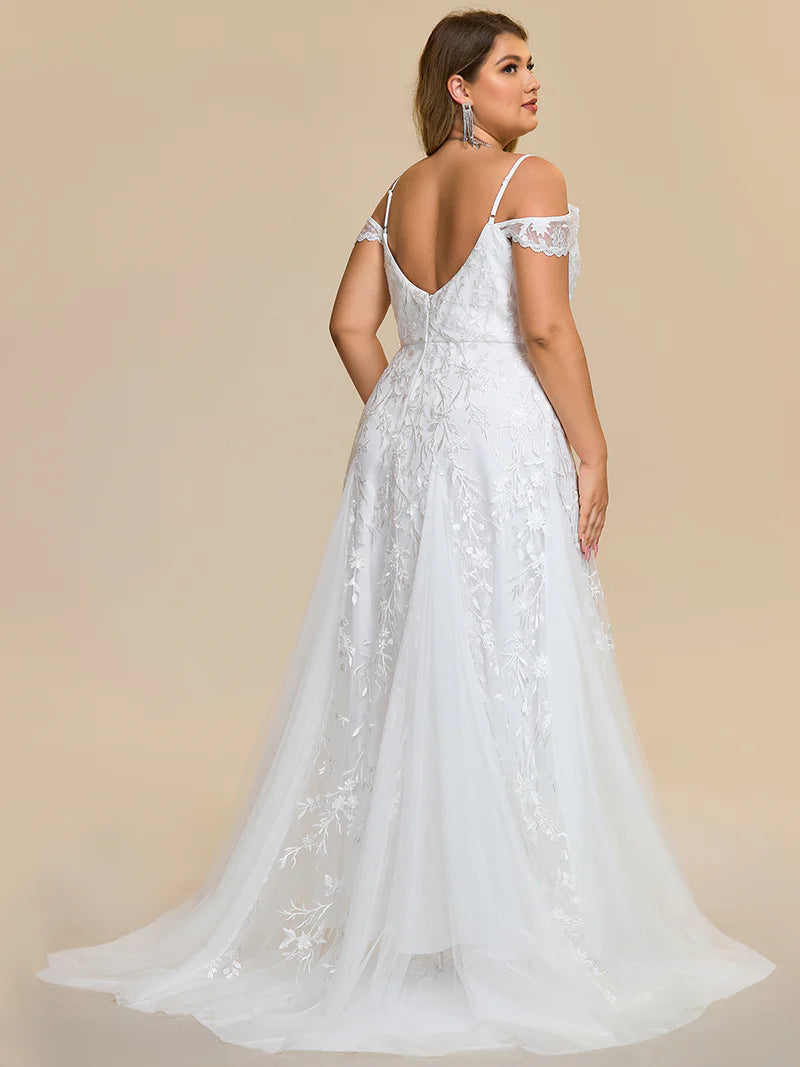 White plus size wedding dress with spaghetti straps and a lace tulle skirt.