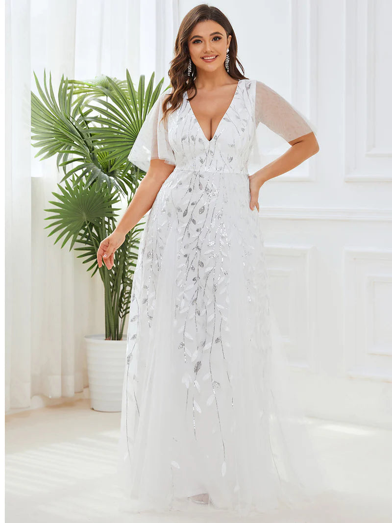 White plus size wedding dress with short sleeves and flowing tulle.
