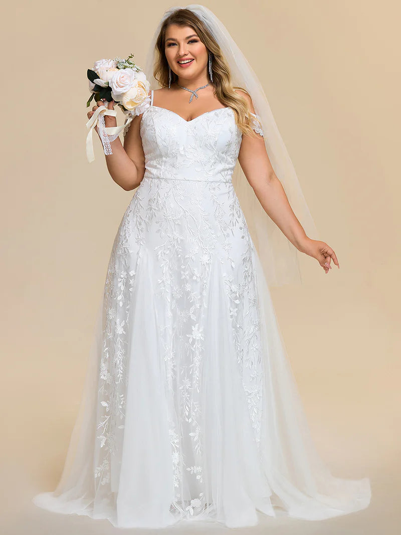 White plus size wedding dress with spaghetti straps and a lace tulle skirt.