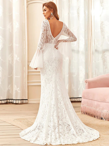White wedding dress with round neck and long pagoda sleeves.
