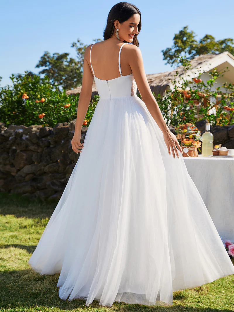 White wedding dress with spaghetti straps and pearl beadings.