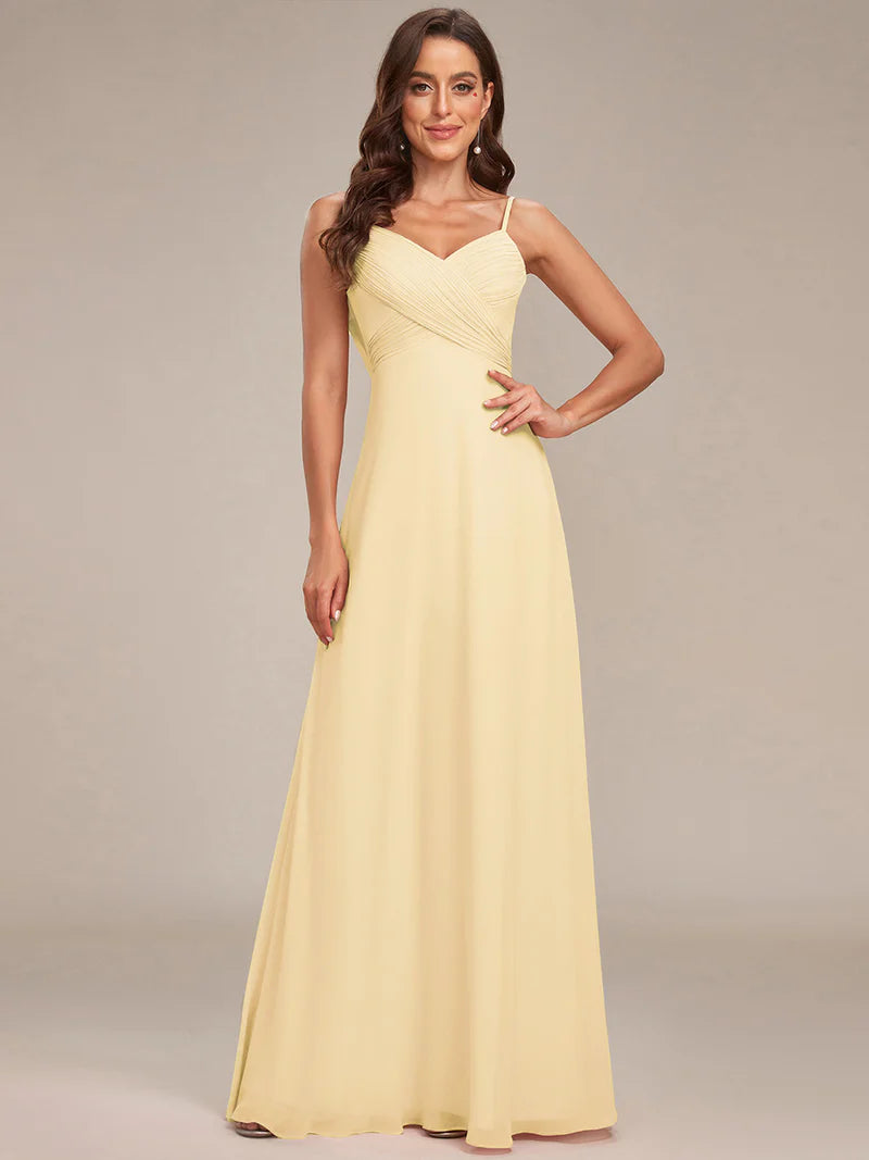 Sleeveless yellow bridesmaid dress with spaghetti straps.