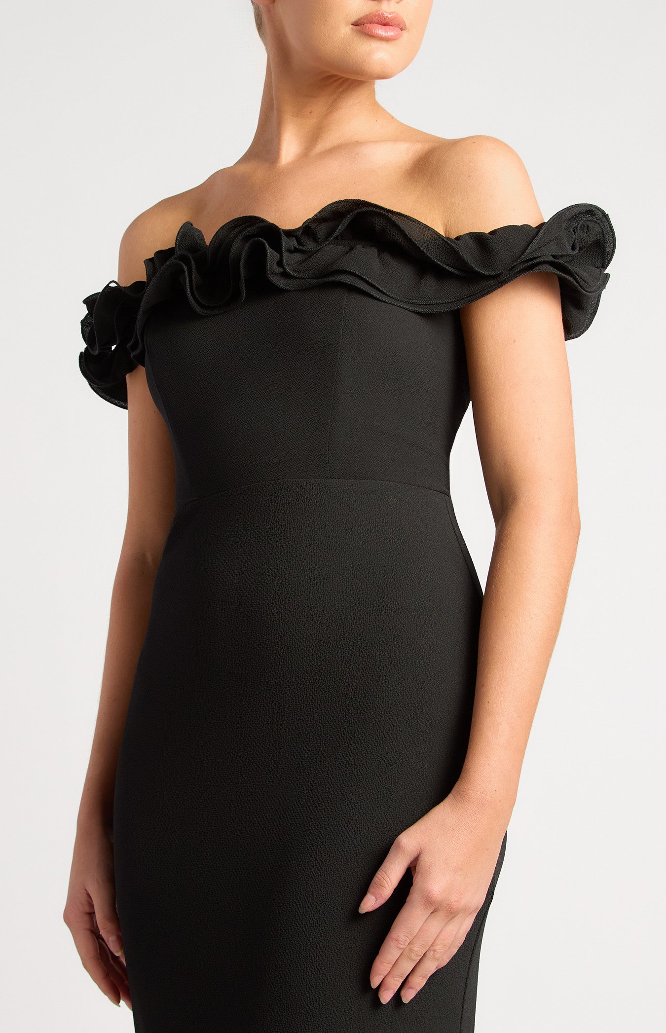 Black formal dress with ruffle neck and off shoulder sleeve.