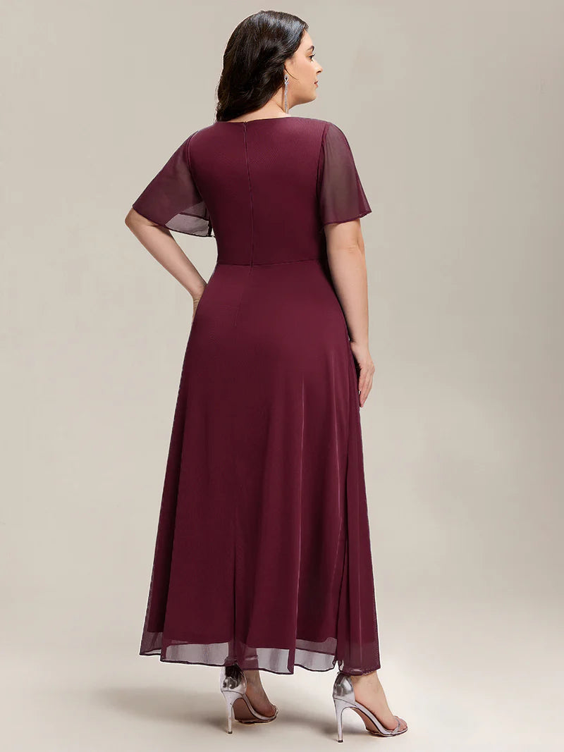 Burgundy plus size wedding guest dress with short sleeves and  rhinestone embellishment.