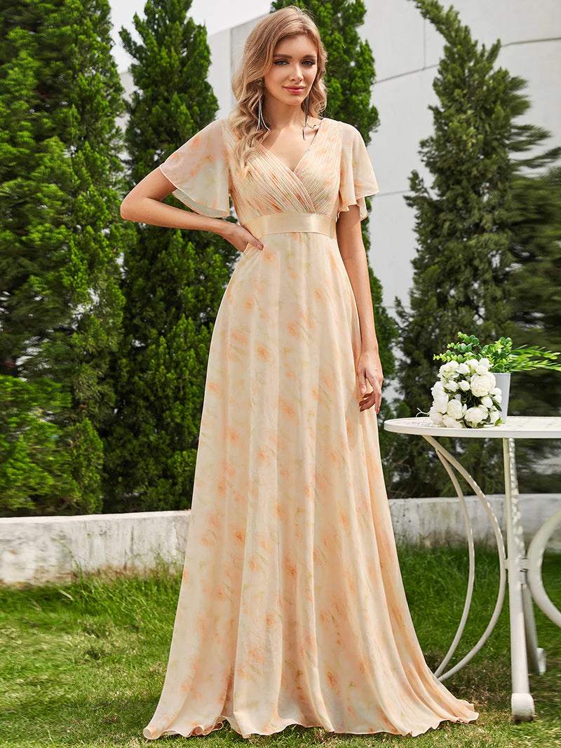 Floral peach formal dress in chiffon with satin band and short sleeves.