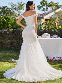 Ivory lace and tulle wedding dress with off the shoulder sleeve. Plus size available.