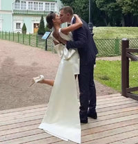 Ivory short satin wedding dress with bow and train.