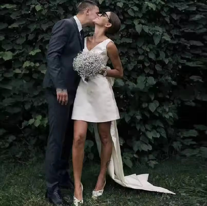 Ivory short satin wedding dress with bow and train.
