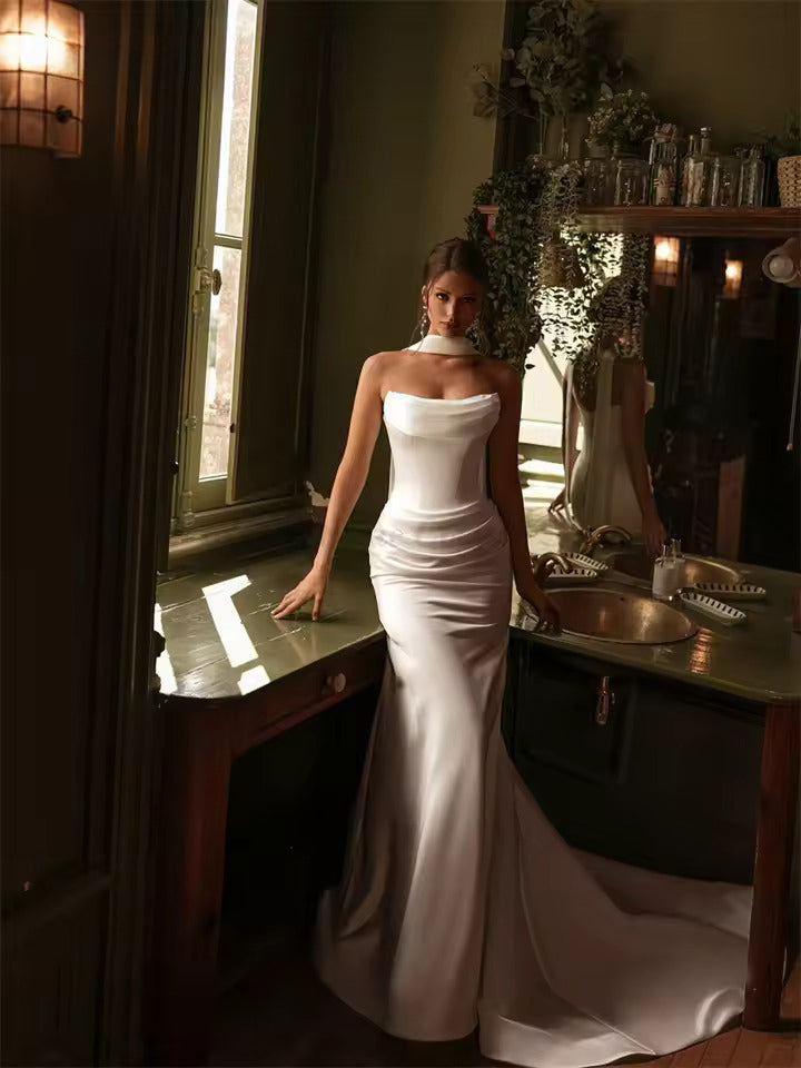 Ivory satin strapless wedding dress with mermaid tail and lace up back.
