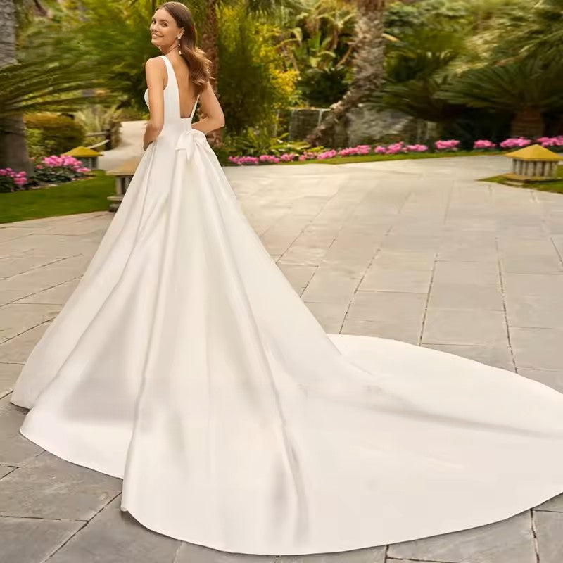 Ivory wedding dress with a deep v neckline, low back, banded waist and train. 