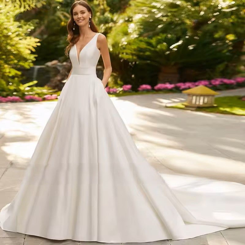 Ivory wedding dress with a deep v neckline, low back, banded waist and train. 