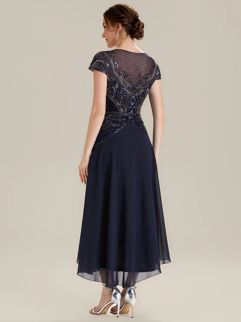 Navy blue mother of the bride dress in tea length short sleeve style with beaded embellishment.