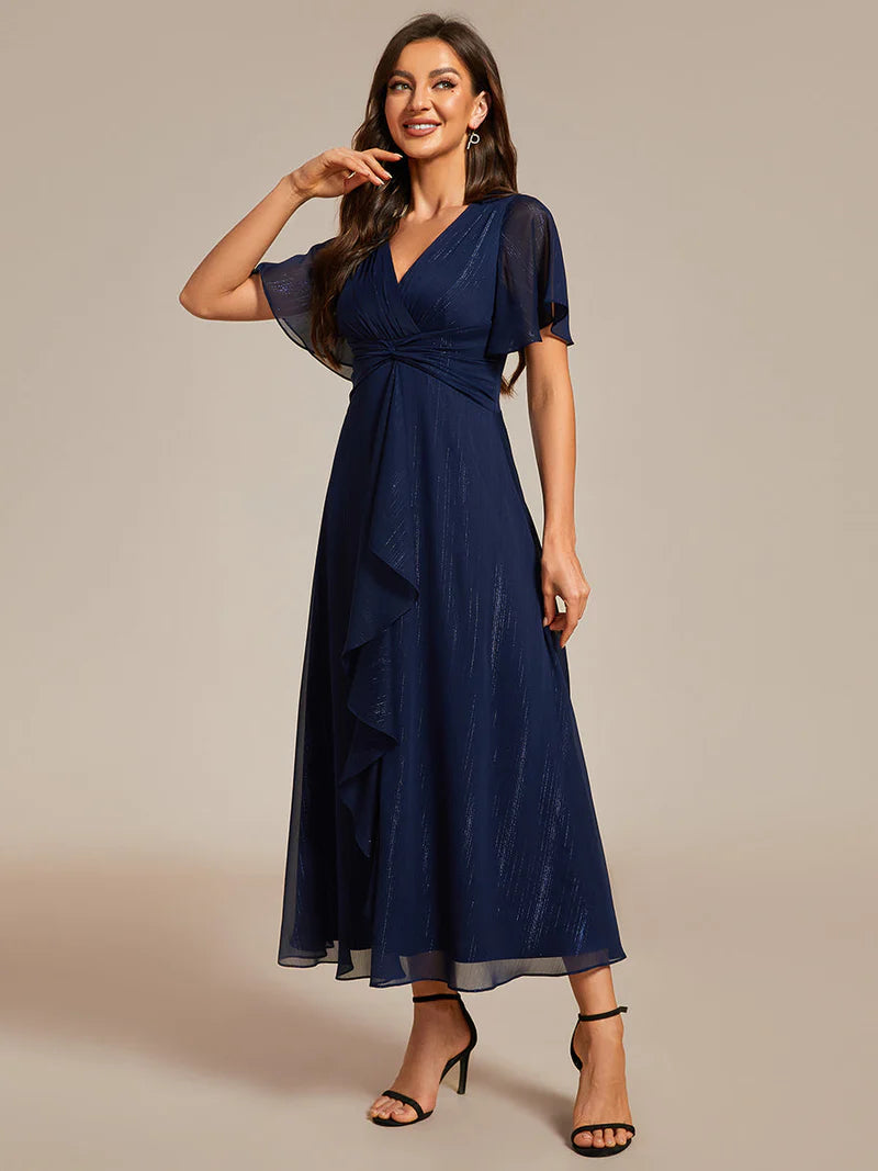 Navy blue plus size wedding guest dress with short sleeve and ruffle front.
