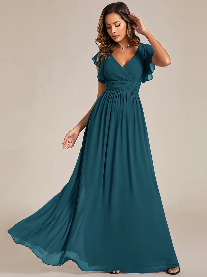 Teal bridesmaid dress with ruffle sleeve and open back detail.