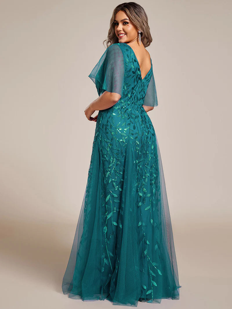 Teal plus size mother of the bride dress with short sleeves and flowing tulle.