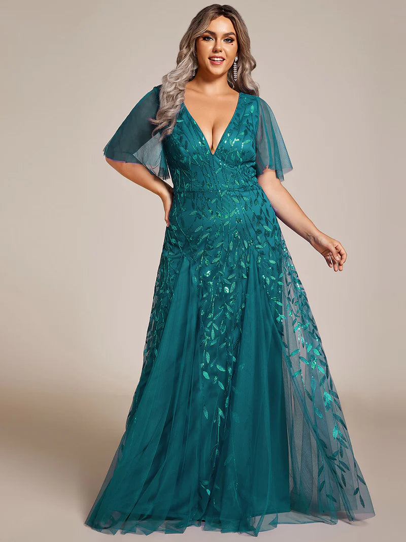 Teal plus size mother of the bride dress with short sleeves and flowing tulle.