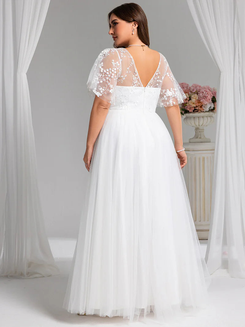 White plus size wedding dress with lace short sleeves and tulle skirt.