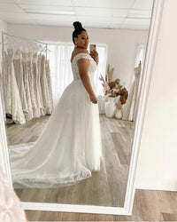 White plus size wedding dress off shoulder style with lace up back and applique tulle.