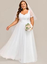 White plus size wedding dress with short sleeves and corset style front.