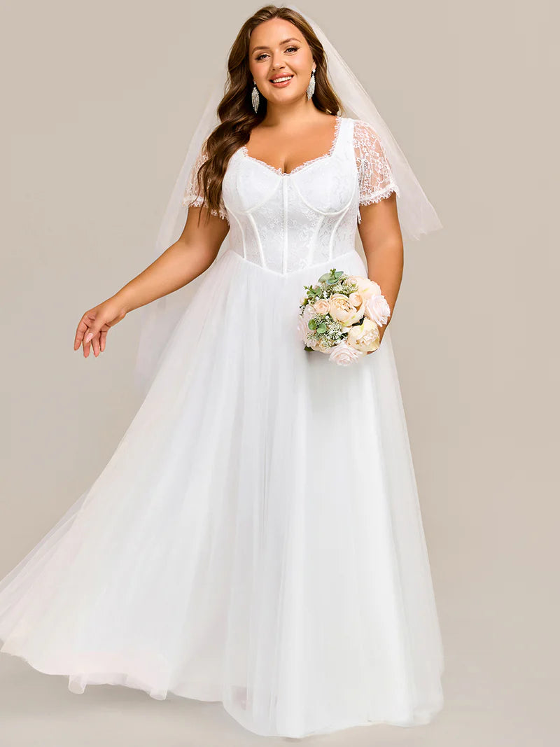 White plus size wedding dress with short sleeves and corset style front.