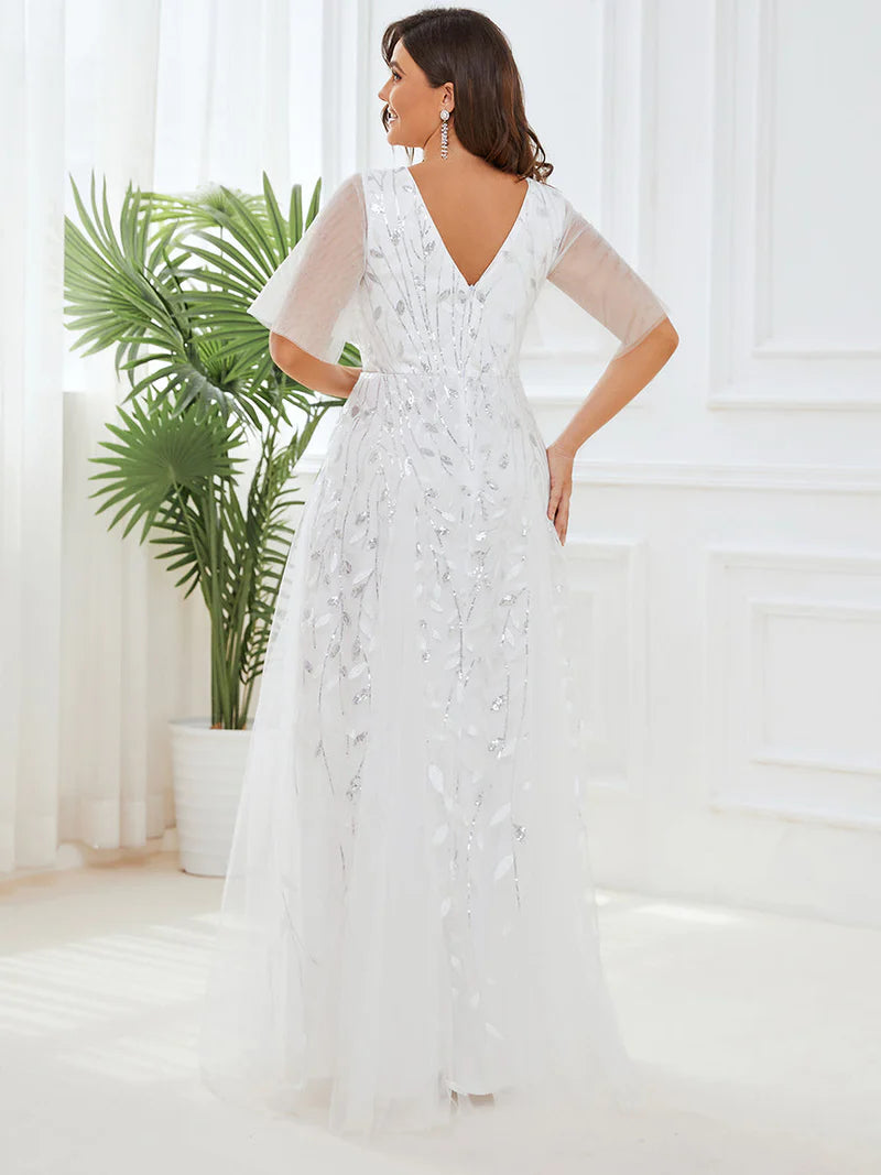 White plus size wedding dress with short sleeves and flowing tulle.