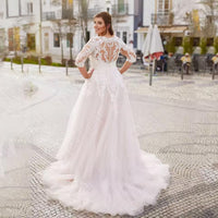 White plus size wedding dress with three quarter lace sleeves and tulle skirt.
