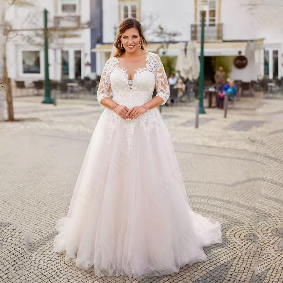 White plus size wedding dress with three quarter lace sleeves and tulle skirt.