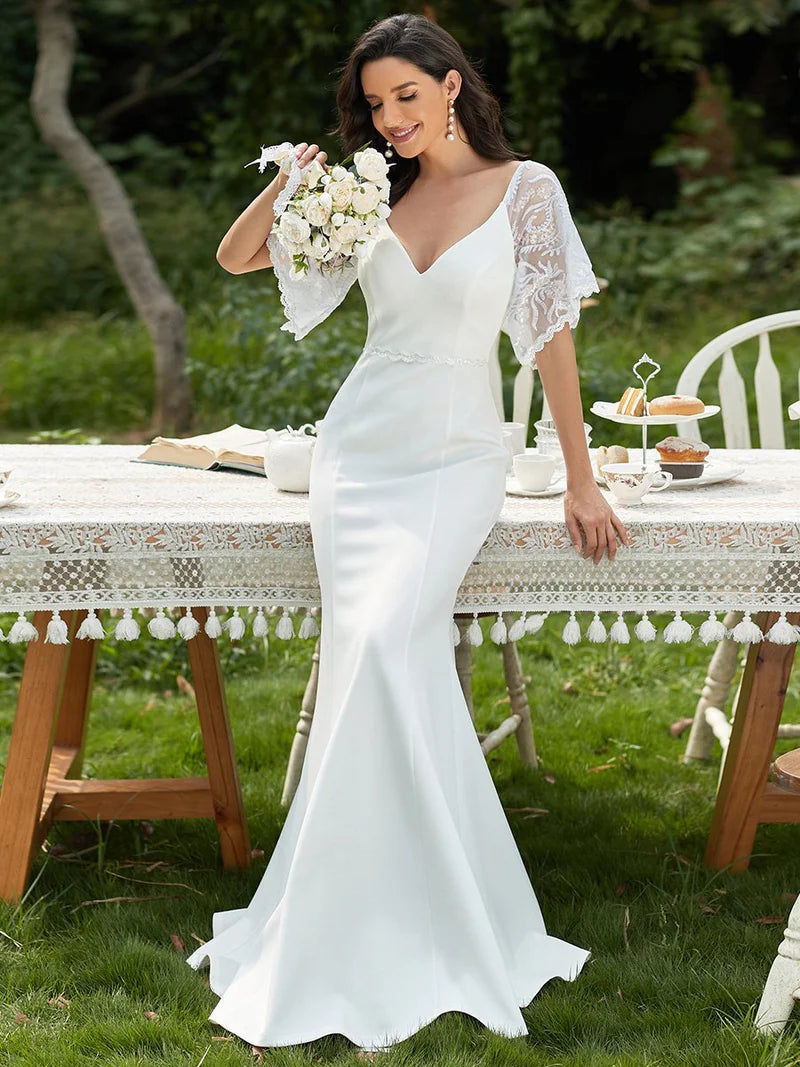 White wedding dress with v-neck, lace sleeves and fishtail.